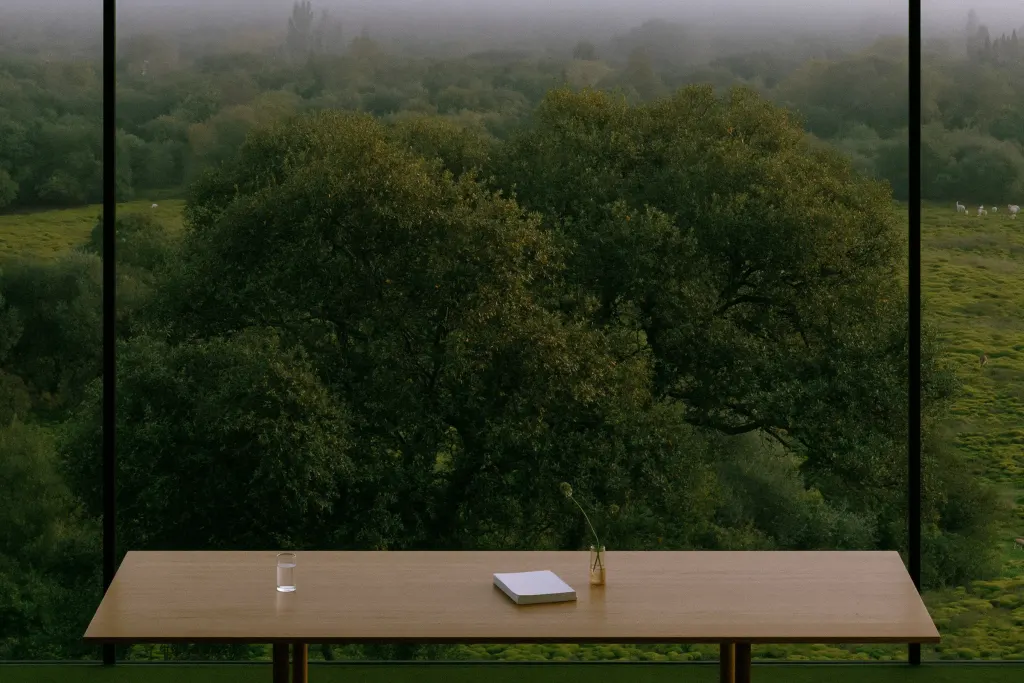 Eichentisch vor einem Fenster mit Blick auf Baum und Wiese