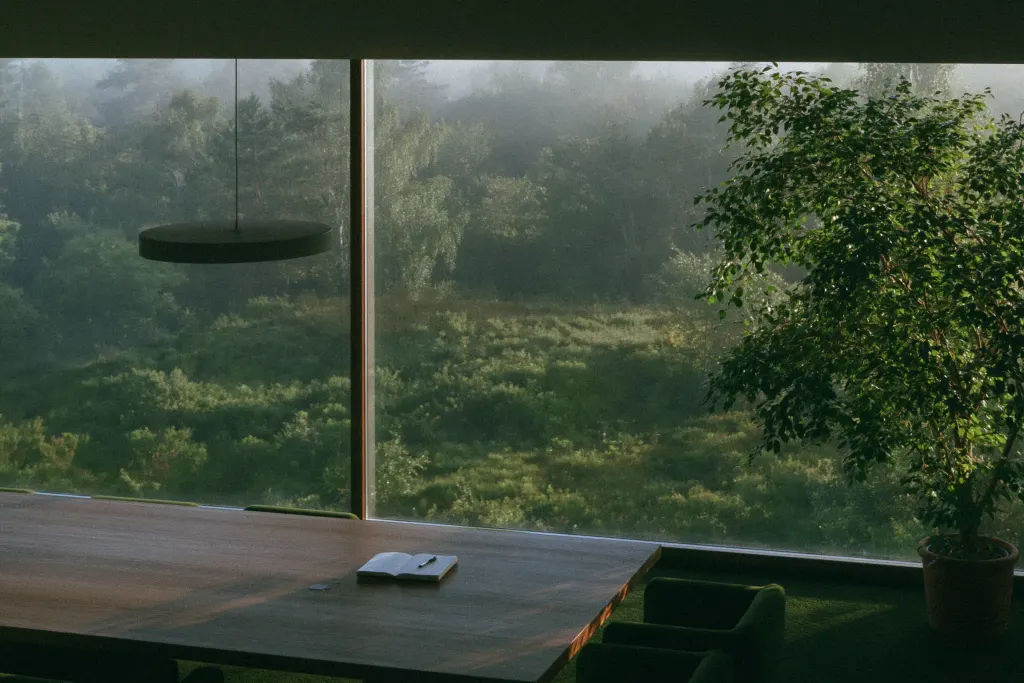 Besprechungstisch an einer Glasfront mit Blick auf nebligen Wald
